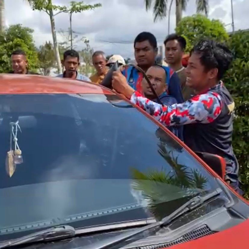Petugas berupaya membuka pintu mobil yang terkunci. (Dok. Disdamkarmatan Kukar)