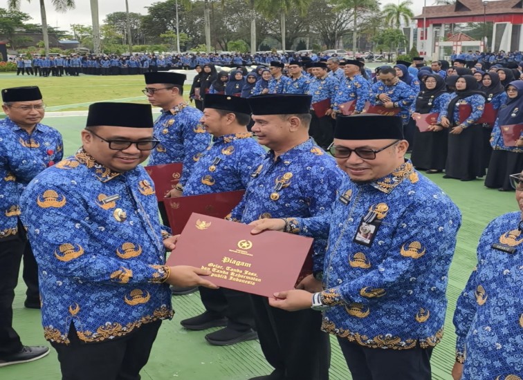 Kadisdikbud Kukar Heriansyah saat menerima Satyalancana Karya Satya di halaman kantor bupati Kukar, (and/dutakaltimnews.com)