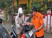 Petugas BPBD Kukar membagikan masker gratis kepada pengendara roda dua. (Dok. BPBD Kukar)