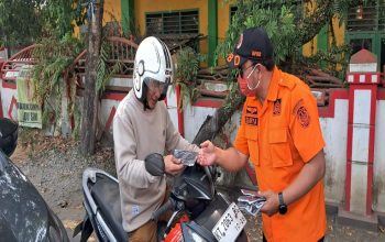 Petugas BPBD Kukar membagikan masker gratis kepada pengendara roda dua. (Dok. BPBD Kukar)