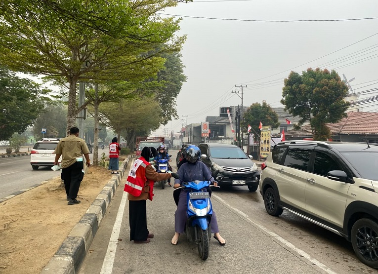 Suasana Pembagian Masker Oleh BPBD Kukar, di Simpang simpang 3 lampu merah Pulau Kumala. (Van/dutakaltimnews.com)
