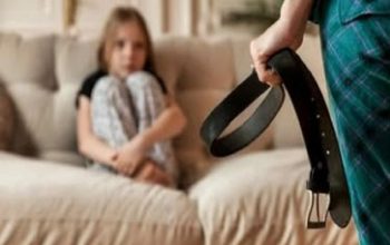Seorang ibu memegang ikat pinggang di hadapan anak perempuannya. (Dok. Shutterstock)